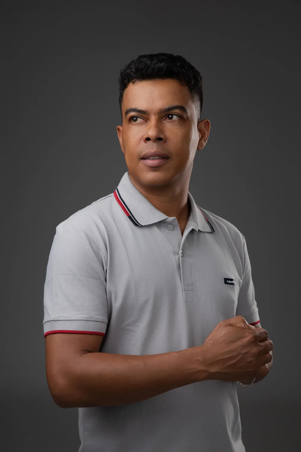Retrato de Nilson Santos de camisa polo cinza, olhando para o lado